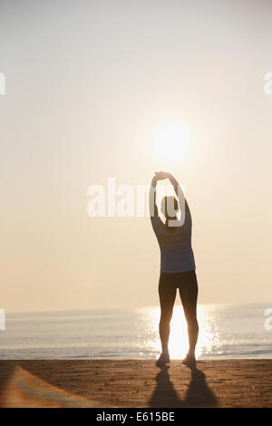 A calm girl stretching her whole body touching the tip of a leg after