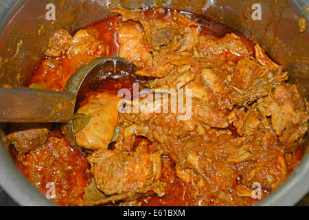 Top view of Chicken curry and a steel ladle in a steel vessel. Stock Photo