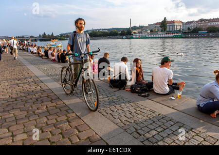 Prague Naplavka, Young people on a waterfront, biker, Prague bike Czech Republic Czech man with a bicycle man pushing bicycle Stock Photo