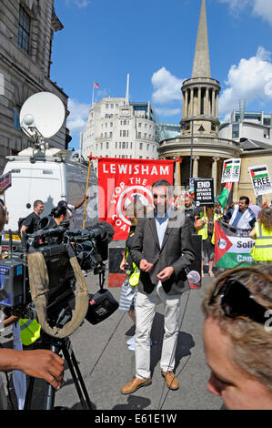 Television journalist doing an outside broadcast  in Regent Street by BBC Broadcasting House during the march for Gaza, Aug 2014 Stock Photo