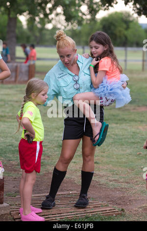 Female counselor holds girl camper in costume at Camp Champions, a sleep-over summer camp on Lake LBJ in Central TX Stock Photo