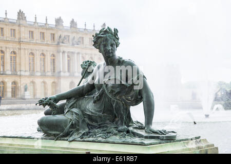 Sculptures and statues in the Gardens of Versailles with the Palace of Versailles in the background, France Stock Photo