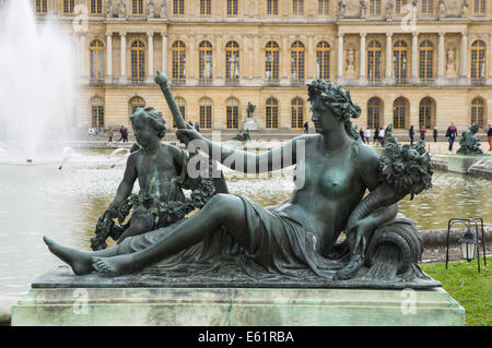 Sculptures and statues in the Gardens of Versailles with the Palace of Versailles in the background, France Stock Photo