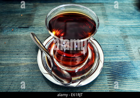 Traditional Turkish tea in glass on blue background
