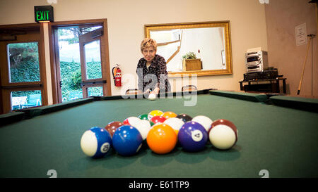 Elderly woman playing billiards Stock Photo