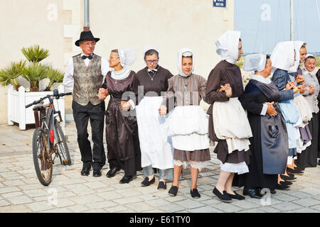 LE CROISIC, FRANCE - JULY 26, 2014: group amateurs in national dresses dancing folk breton dance outdoors in Le Croisic town, Fr Stock Photo