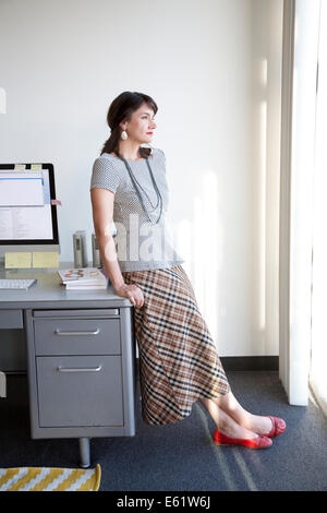 Businesswoman relaxing at her desk in office Stock Photo