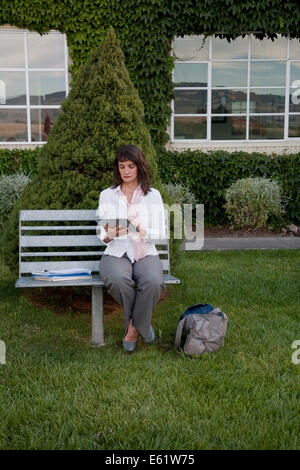 Businesswoman working on bench Stock Photo
