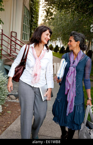 Two women walking and talking Stock Photo