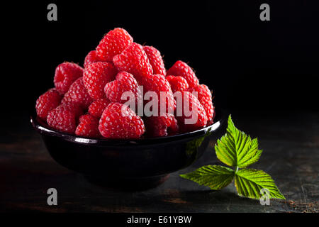 Bowl of fresh raspberry on dark background Stock Photo