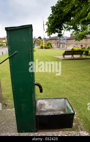 UK England, Dorset, Stalbridge, old village water pump on green Stock Photo