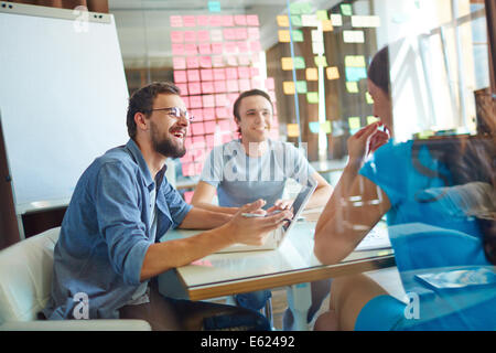 Young business partners sharing ideas and planning work at meeting in office Stock Photo