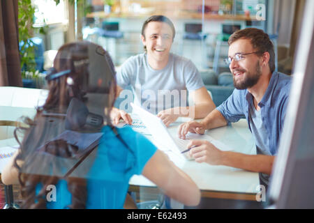 Young business partners discussing ideas or project at meeting in office Stock Photo