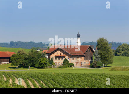 Church in Schonstett with Schwöll estate, Chiemgau, Upper Bavaria, Bavaria, Germany Stock Photo