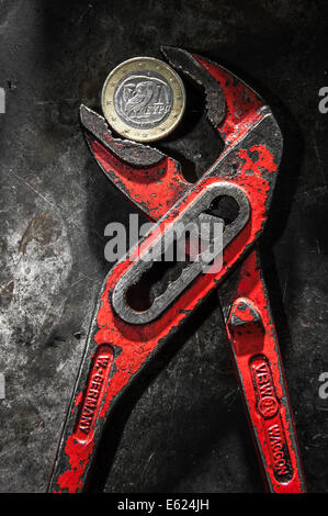 A Greek euro coin under pressure in a monkey wrench Stock Photo