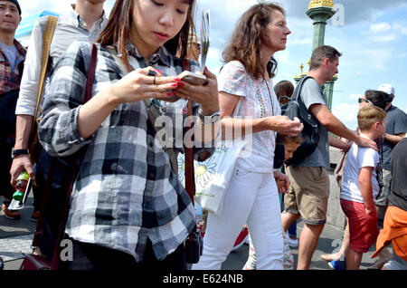 London, England, UK. Young Asian woman walking and using her mobile phone Stock Photo