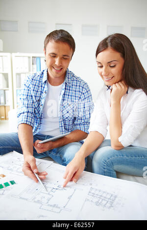 Portrait of young couple discussing sketch of their new flat Stock Photo