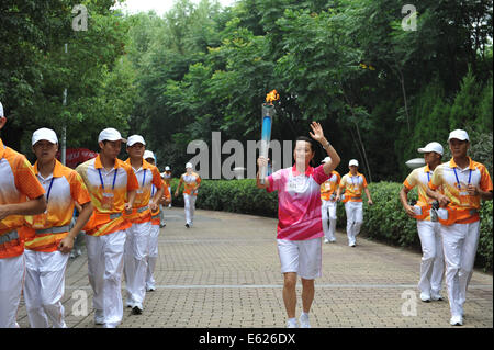 Nanjing. 12th Aug, 2014. Torch bearer Tao Jie holds the Olympic torch during the torch relay of the Nanjing 2014 YOUTH OLYMPIC GAMES in Nanjing, capital of east China's Jiangsu Province, on Aug.12, 2014. The Nanjing 2014 Youth Olympic Games will be held from August 16 to 28. Credit:  Li Xiang/Xinhua/Alamy Live News Stock Photo