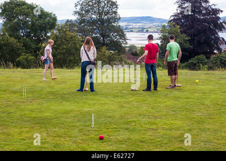 August 2014. A group of students and friends playing croquet on the lawn in front of A La Ronde country house in Exmouth, Devon. Stock Photo