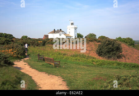 A view of walkers on the cliff top footpath to the lighthouse at Cromer, Norfolk, England, United Kingdom. Stock Photo