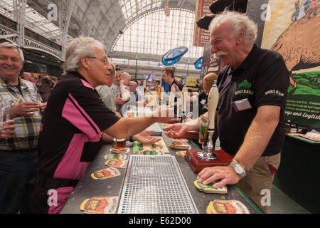 Olympia, London, UK. 12th Aug, 2014. Visitors to the CAMRA Great British Beer Festival sample Hog's Back Brewery's ales. Credit:  Paul Davey/Alamy Live News Stock Photo