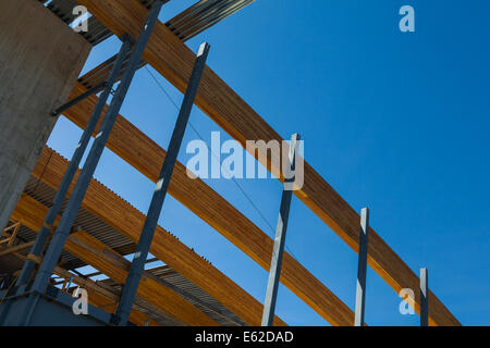 Array of large laminated wooden beams used as a roof support in an open-plan building Stock Photo