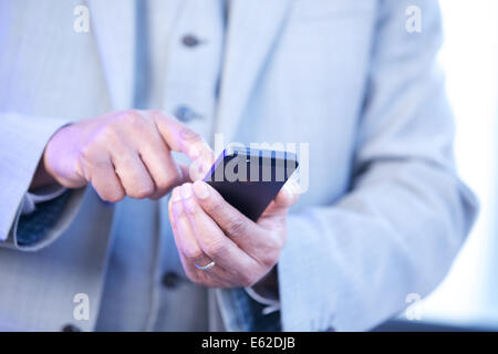 Close up of man in suit using an iphone Stock Photo