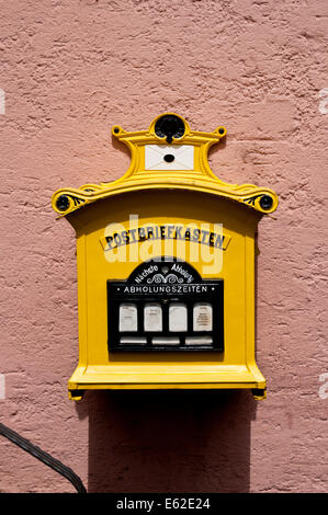 Traditional yellow postbox (Ger: Postbriefkasten) in Cochem, Germany Stock Photo