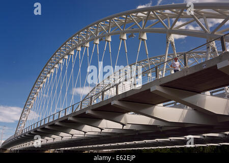 Jogger on new Strandherd Armstrong steel suspension bridge over the Rideau River Ottawa Canada Stock Photo