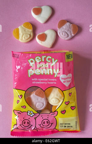 Bag of Marks & Spencer new percy and penny with special lovers strawberry hearts sweets together at last open with contents spilt isolated on pink Stock Photo