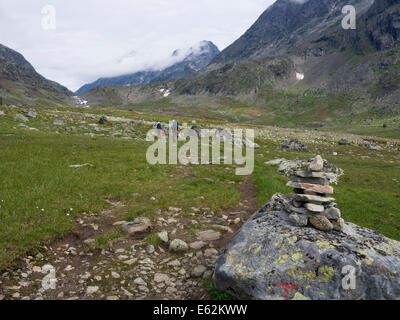 Two hikers entering Svartdalen mountain pass in he National park of Jotunheimen in Norway,  footpath through moraine material Stock Photo