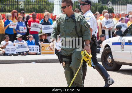 US Park Police SWAT policeman tying police line tape on barricade fence