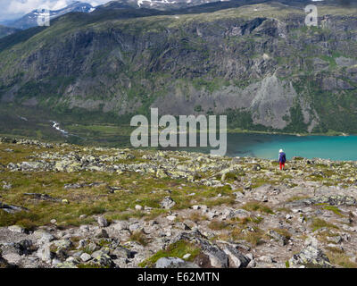 Jotunheimen National Park Norway,female hiker looking down at lake Gjende and Gjendebu lodge from Svartdalen mountain pass Stock Photo