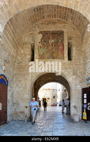 Tourist strolls under the archway leading to the Old Town at Polignano a Mare Stock Photo