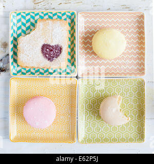 Macarons and cookie on square pastel plates Stock Photo