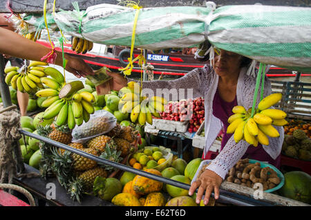 Woman selling fruit & vegetables on boat, Cai Be floating market, Vietnam Stock Photo