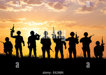 silhouette of  Soldiers team with sunrise background Stock Photo