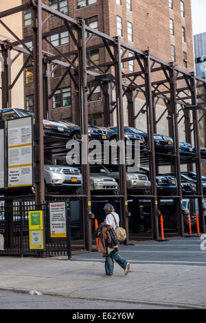 Manhattan, New York. People Pass by multi-story parking lot. Stock Photo