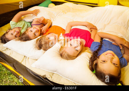 Five pretty kids lay covered with blanket Stock Photo