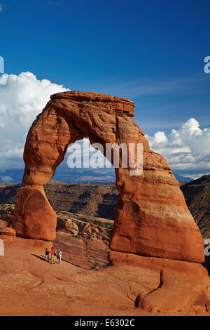 Delicate Arch (65 ft / 20 m tall iconic landmark of Utah), and tourists, Arches National Park, near Moab, Utah, USA Stock Photo