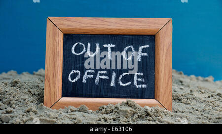 Out of office written on a chalkboard at the beach Stock Photo