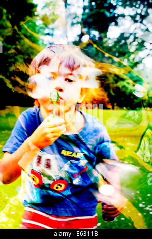 A six year old boy blowing bubbles Stock Photo