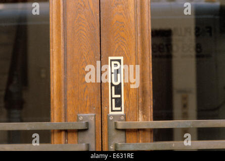 PULL SIGN ON WOODEN PANEL OF DOOR Stock Photo