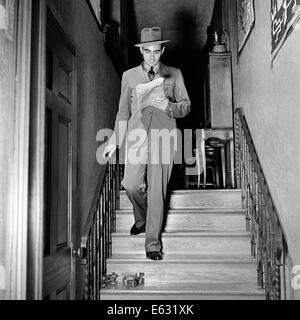 1930s 1940s ACCIDENT ABOUT TO HAPPEN MAN WALKING DOWN STAIRS SLIP ON PAIR OF ROLLER SKATES Stock Photo