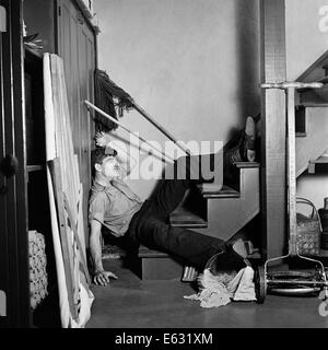 1930s 1940s MAN LYING AT BOTTOM BASEMENT STAIRS FALLEN HOUSEHOLD ACCIDENT INJURY Stock Photo