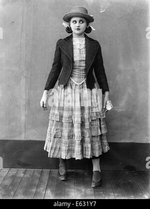 1910s 1920s TEEN GIRL LOOKING OFF TO THE SIDE WEARING RUFFLED SKIRT STRAW HAT SHORT JACKET SILENT MOVIE STILL Stock Photo
