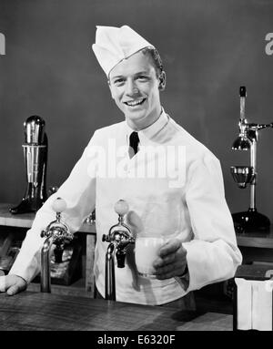 1940s 1950s SMILING SODA JERK BEHIND COUNTER HOLDING GLASS OF MILK