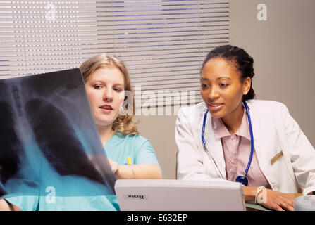 1990s TWO FEMALE MEDICAL STUDENTS LOOKING AT X-RAY Stock Photo