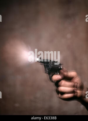 1980s BLUR MOTION OF A HAND SHOOTING REVOLVER GUN SMOKE AND FLASH COMING OUT OF MUZZLE Stock Photo