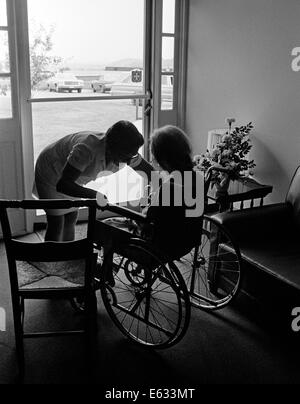 1970s ANONYMOUS SILHOUETTED NURSE HELPING ELDERLY PERSON SITTING IN WHEELCHAIR ALL IN SILHOUETTE Stock Photo